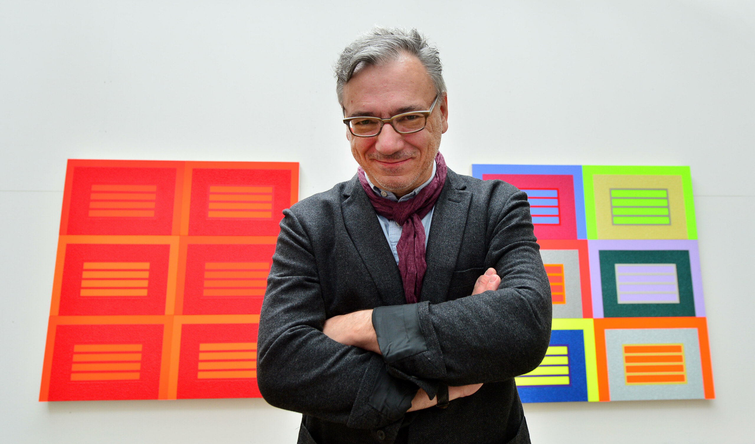 E09TP7 Jena, Germany. 07th May, 2014. US artist Peter Halley poses in front of his pictures in his exhibition 'Prisons' in Jena, Germany, 07 May 2014. The exhibition runs from 10 May until 27 July 2014. Photo: MARTIN SCHUTT/dpa/Alamy Live News