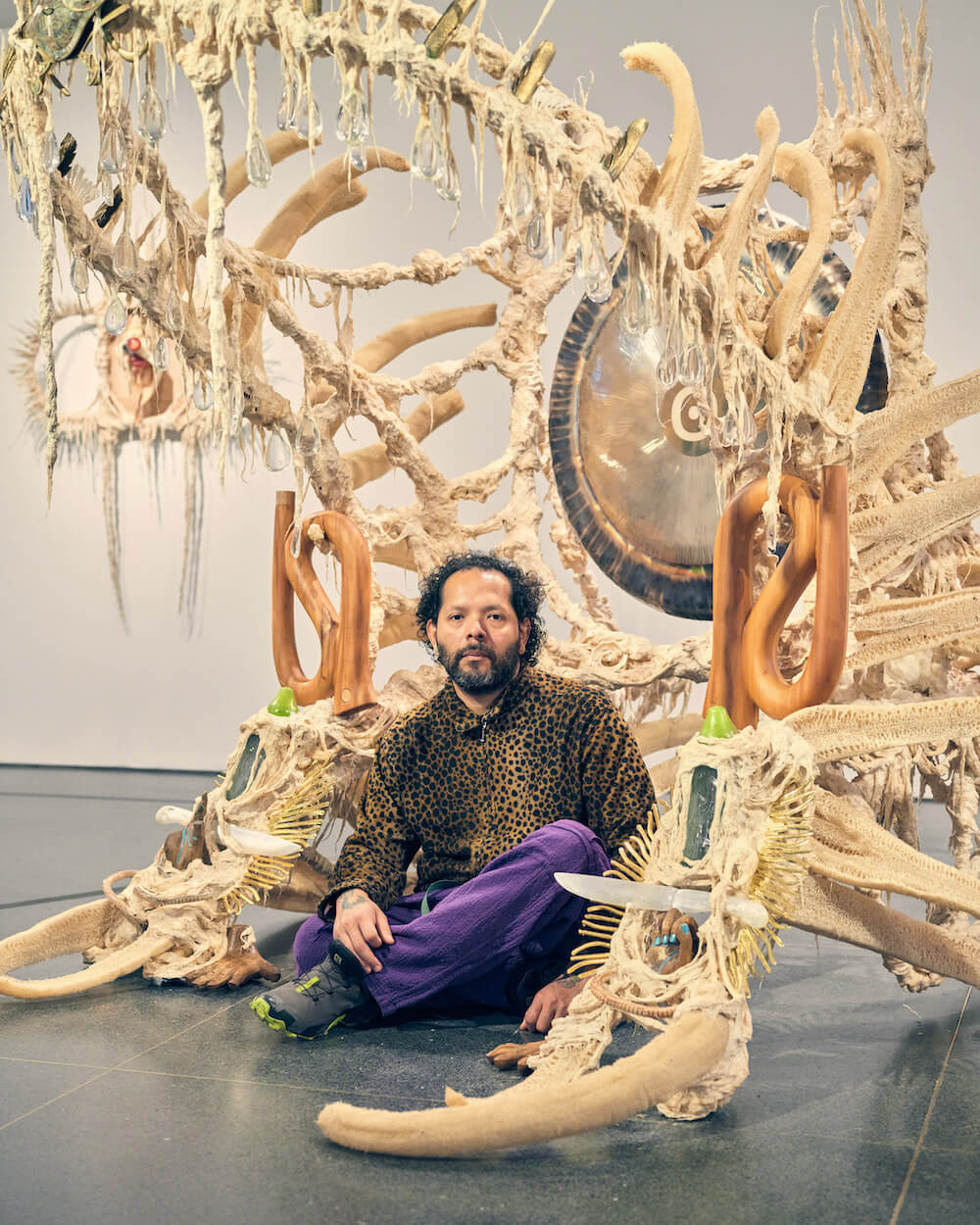 BROOKLYN, NY - 4/22/22: 

Artist Guadalupe Maravilla photographed in one of the galleries of his show “Tierra Blanca Joven” on view from April 8 to September 18, 2022 at the Brooklyn Museum. The piece he is photographed in here is titled “Disease Thrower #18”

CREDIT: Christopher Gregory for National Public Radio